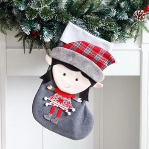 Calza di Natale grigia con ragazza 3D sul camino bianco con decorazioni natalizie
