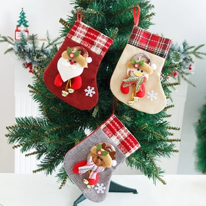 Three Christmas stockings set with Santa, Snowman and Reindeer hanging on a tree