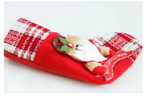 Close-up of red Christmas stocking with 3D Santa plush and Merry Christmas wood plaque