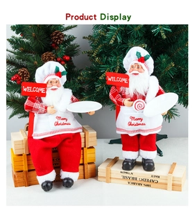 Detail of chef Santa Claus figurine holding welcome sign and plate for holiday decor
