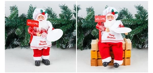 Detail of chef Santa Claus figurines with Merry Christmas apron and welcome sign