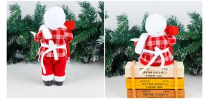 Detail of fabric Santa chef figurine in red plaid outfit sitting on a wooden crate