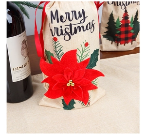 Close-up of burlap Christmas wine bag with a large red poinsettia and ribbon drawstring