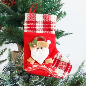 Red Christmas stocking with Santa Claus and Merry Christmas banner hanging on tree