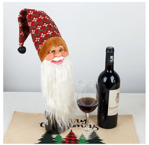 Detail of knitted Santa wine bottle cover with gold glasses and long white beard decoration