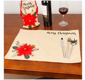 Detail of Christmas placemat and wine bottle cover with red poinsettia floral decorations