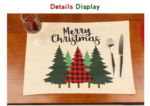 Close-up of linen Christmas placemat with Merry Christmas print and festive tree patterns