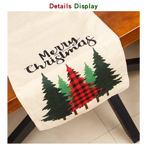 Detail of linen Christmas table runner featuring Merry Christmas text and plaid trees