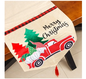Detail of Christmas table runner with red truck, dwarf motifs and decorative red tassel