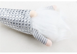 Gros plan d'un gnome de Noël à paillettes argentées avec barbe blanche et bras rayés
