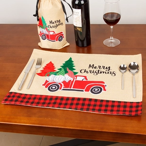 Christmas table mat and wine bottle cover set with truck and gnome design on wooden table