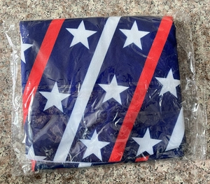 Detail of USA Independence Day tree skirt folded in clear packaging on stone texture