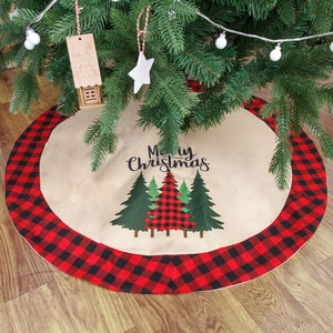 Christmas tree skirt with buffalo plaid edge and Merry Christmas print on wood floor
