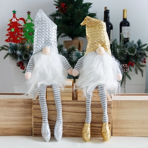 Pareja de gnomos navideños con sombreros dorados y plateados sobre caja de madera