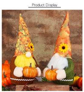Detail of two autumn gnomes with sunflower hats holding mini pumpkins for harvest decor