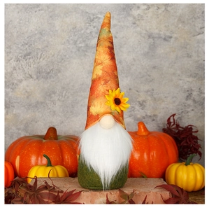 Close-up of autumn gnome with maple leaf hat and sunflower detail on gray background