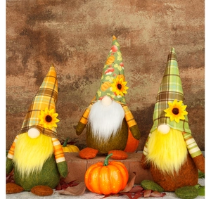 Primer plano de tres gnomos de otoño con sombreros de calabaza y girasoles en ladrillos