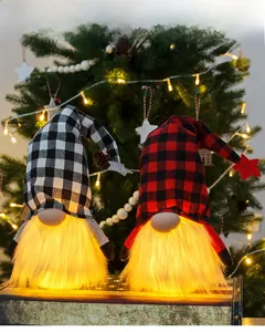 Detail von zwei leuchtenden Weihnachtswichteln mit Karomustern und warmen LED-Lichtern