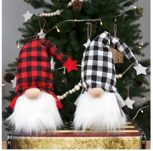 Detailansicht von zwei leuchtenden Weihnachtswichteln mit Karomuster auf einem Retro-Koffer