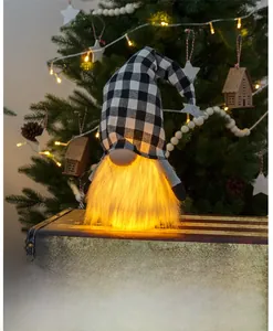 Makro-Detail vom leuchtenden Weihnachtswichtel mit karierter Mütze auf einem alten Koffer