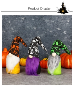 Three Halloween gnomes with skull hats and plush beards set against pumpkin decor