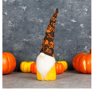 Close-up of Halloween gnome with skull pattern hat and beard among orange pumpkins