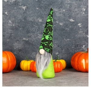 Detail of Halloween gnome featuring black hat with neon green skull and pumpkin decor