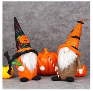 Detail of plush Halloween gnomes with spider web hats and pumpkin accents for decoration