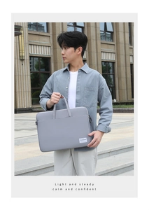 Detail of grey laptop briefcase with white brand label and durable carry handle