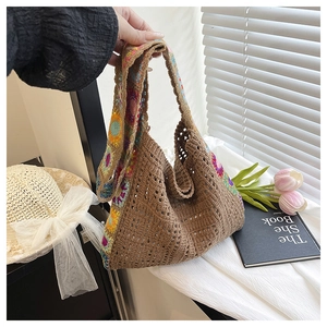 Detail of hand-woven brown straw tote bag with colorful bohemian floral crochet patterns