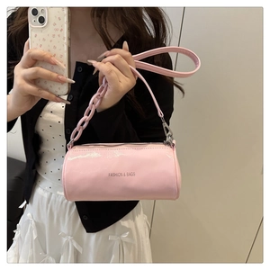 Vue détaillée d'un sac cylindrique rose avec grosse chaîne et lettrage FASHION & BAGS