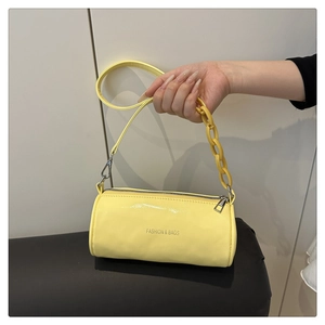Détail du sac cylindrique jaune avec chaîne en plastique et logo imprimé
