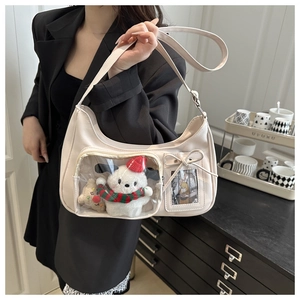 Detail view of cream shoulder bag with clear front pocket and cute puppy plush toy