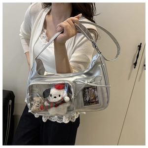 Metallic silver handbag with a clear window displaying a plush toy and bow detail