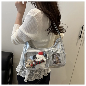 Detail of silver ita bag with clear window showing plush toys and bow decoration