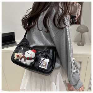 Detail of black ita bag with clear PVC window showcasing cute plush toys inside