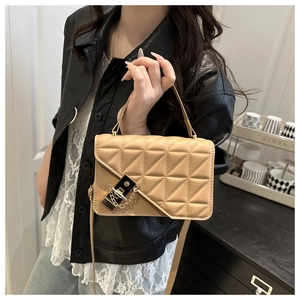 Dettaglio borsa trapuntata beige con chiusura in metallo dorato e manico superiore