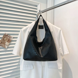 Minimalist black woven tote bag with premium faux leather texture on white background