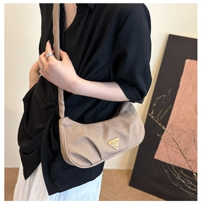 Dettaglio borsa hobo color caffè chiaro con trama in tessuto e logo triangolare