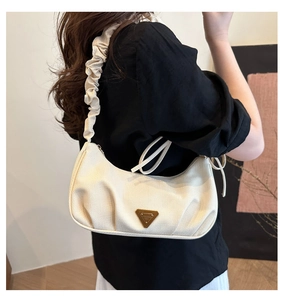 Detail of cream pleated shoulder bag with knit texture and metal triangle logo