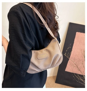 Dettaglio della borsa a nuvola marrone con texture plissettata e logo in metallo
