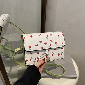 Piccola borsa a tracolla bianca con stampa ciliegie e sottile tracolla verde chiaro