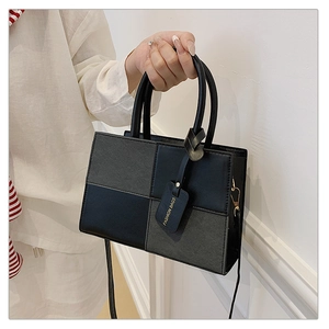 Detail shot of the two-tone contrast paneling and premium texture on a square tote bag