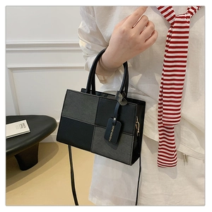 Detail of color-block square handbag with matte PU leather and decorative hanging tag