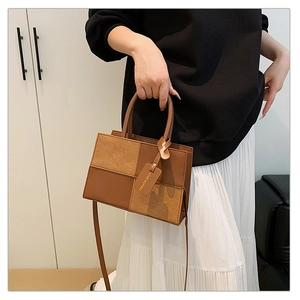 Close-up of geometric patchwork texture on brown square handbag with brand tag
