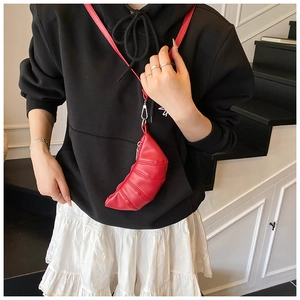 Macro view of red pleated croissant bag with leather texture and zip closure