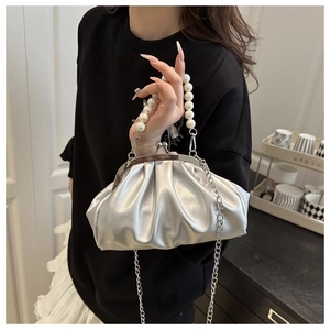 Detail of silver pleated cloud bag with pearl handle and metal chain strap