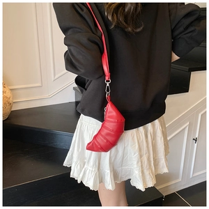 Close-up of red pleated croissant bag with quilted texture and silver metal hardware