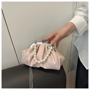 Close-up of pink pleated cloud bag with pearl handle and vintage silver metal clasp