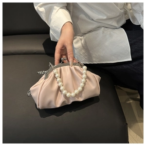 Detail of light pink pleated cloud bag with large pearl handle and silver metal chain